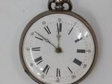 clock with roman numerals on the face of it hanging on a wall