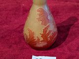 un petit vase posé sur un tissu rouge