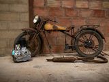 a old motorcycle that is sitting in front of a brick wall