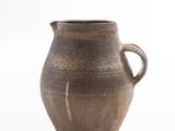 a brown vase that is sitting on a white surface