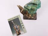 a book and a statue of a bird on a table