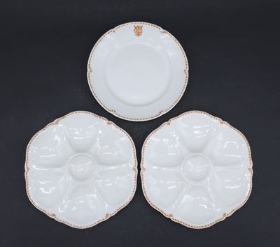 three white plates with gold rims on a black surface