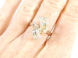 a woman ' s hand holding a diamond and gold ring