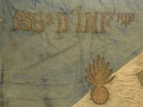 a blue and white cloth with gold letters and a pineapple on it