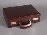 a brown suitcase sitting on a table with a handle