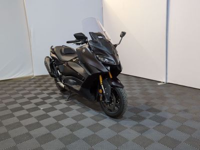 a black motorcycle parked in a room with a checkered floor