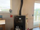 a small stove in the middle of a room with a table and chairs