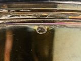 a close up of a silver clock on a table