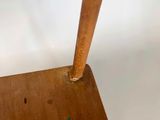 a wooden chair that has a wooden seat on it