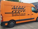 an orange van parked in front of a building with a red garage behind it