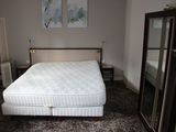 un lit qui se trouve dans une chambre où il y a un miroir accroché au mur