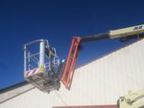 a man on a cherry picker working on the side of a building