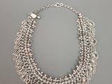 un collier en argent sur fond gris