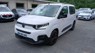 une camionnette blanche garée sur un parking, avec d'autres voitures en arrière-plan