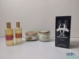 trois flacons de parfum et une boîte de lait corporel posés sur une table