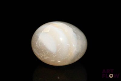 a white marble ball sitting on top of a black surface