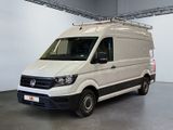 La camionnette blanche est garée dans une grande pièce, avec une échelle sur le toit.