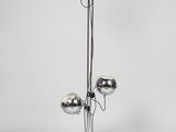 un lampadaire chromé muni de trois boules chromées sur son socle