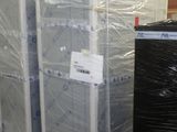 Plusieurs palettes de réfrigérateurs sont emballées dans du plastique dans un entrepôt