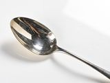 a spoon that is sitting on a white surface