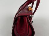 the back of a red handbag with a metal handle