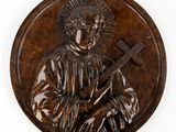 an image of a bronze plaque of a man holding a cross