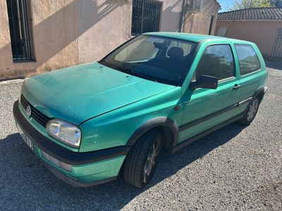 une photo d'une voiture verte garée devant un immeuble