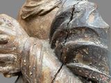 an old statue of a woman holding a flower in her hands