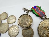 beaucoup de pièces et une médaille posées sur une table