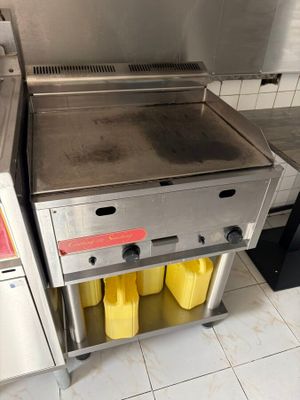 un plan de travail en acier inoxydable sur lequel sont posés deux bacs jaunes, dans une cuisine professionnelle