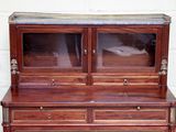 a wooden cabinet with glass doors on top of it