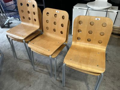 trois chaises en bois percées de trous dans une pièce