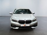 the front view of a silver bmw car in a showroom