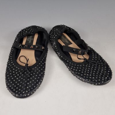 a pair of black shoes with studded straps on them