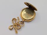 a small gold locke with a flower on it
