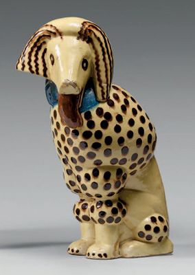 une figurine en céramique représentant un guépard avec un nœud bleu