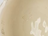 a close up view of a white vase with a flower on it