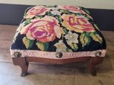 a small foot stool with a floral design on it