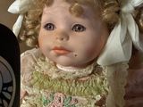 a doll that is sitting next to a bottle of coffee