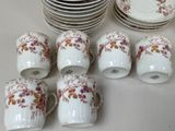 a lot of cups and saucers sitting on a table