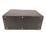 a brown leather suitcase with brass studding on the front