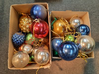 many different colored ornaments in a box on the floor
