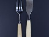 two forks and a knife on a black table