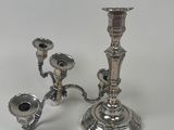 a silver candle holder with two candles on it