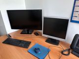 a desk with two computers and a laptop on it