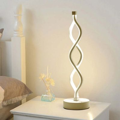 a lamp that is sitting on a table next to a bed
