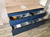 a blue dresser with a wooden top and drawers on it