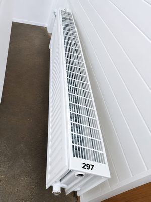 a white radiator sitting on the floor next to a wall