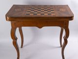 une vieille table en bois sur laquelle est posé un échiquier