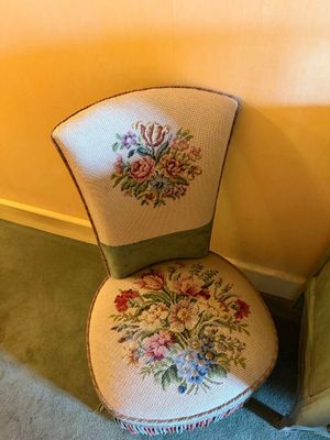 a green chair with a floral design on it next to a green chair